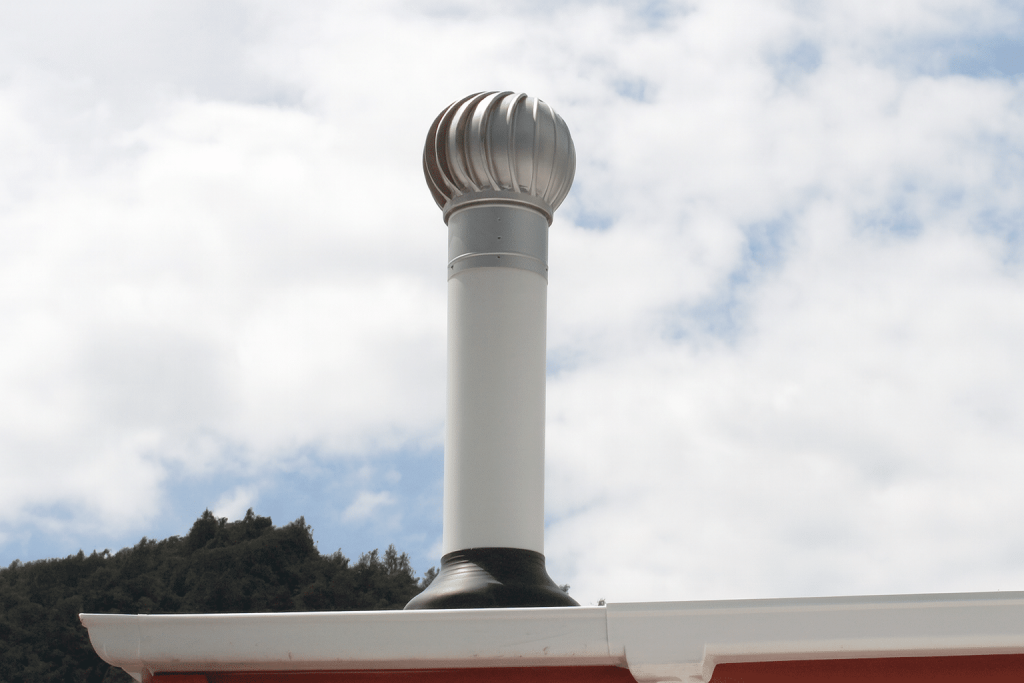 Roof-mounted Skyaxis 200mm with a cylindrical white pipe against a cloudy sky and hillside backdrop.